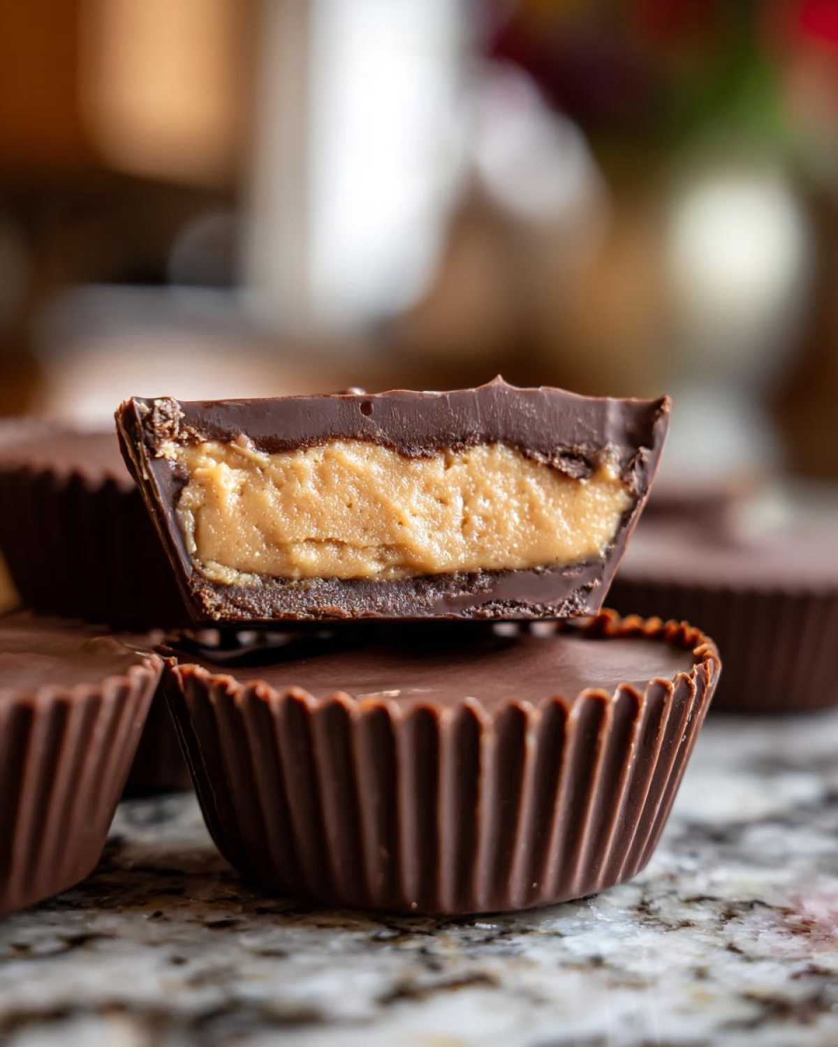 Close-up of a homemade peanut butter cups cut in half showing thick peanut butter filling inside chocolate shell.