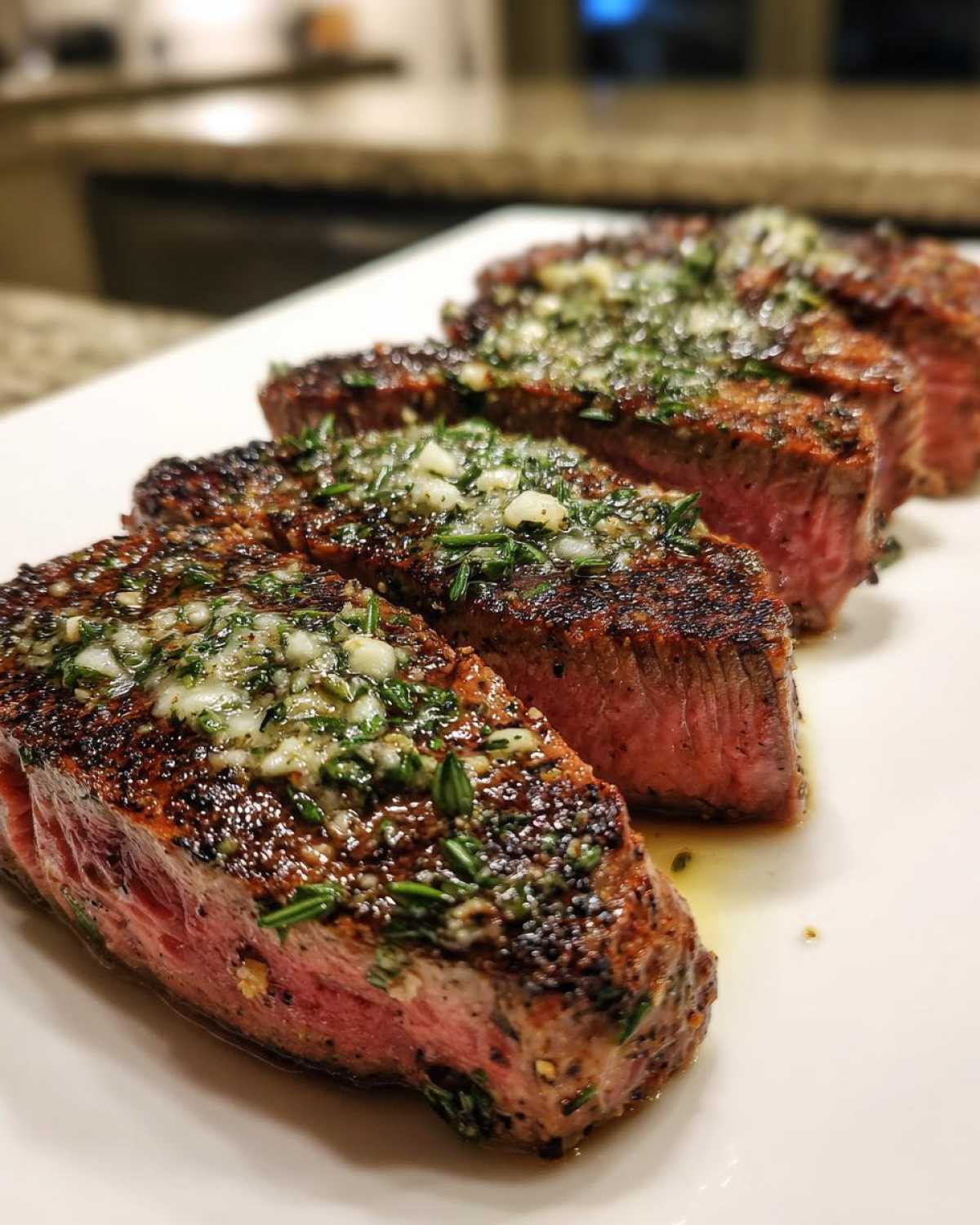 Four thick slices of perfectly seared tuna steak, cooked medium-rare, topped with garlic herb butter.