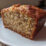 Close-up of a moist slice of Banana Bread Snack Cake Soft Moist Treat on a white plate.