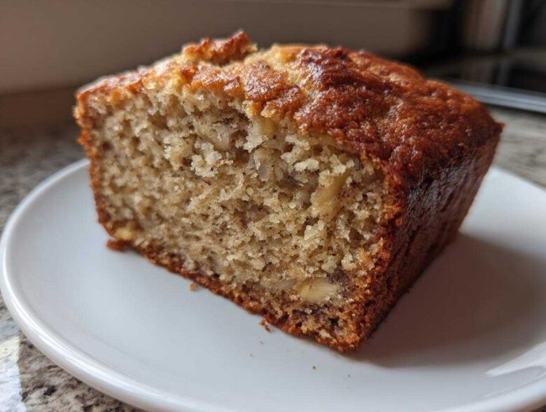 Close-up of a moist slice of Banana Bread Snack Cake Soft Moist Treat on a white plate.
