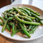 A close-up of bright green beans tossed with grated Parmesan cheese, showcasing The Best Garlic Parmesan Green Beans.