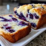 Close-up of a sliced Blueberry Cream Cheese Bread Loaf showing moist interior packed with blueberries.