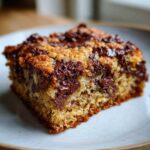 A close-up shot of one moist square of Chocolate Chip Banana Bars with melted chocolate chunks on top.