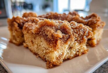 Close-up of three squares of coffee cake featuring a thick, sugary Cinnamon Coffee Cake Crumb Topping.