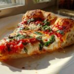 A close-up slice of Classic Homemade Margherita Pizza featuring melted mozzarella, bright tomato sauce, and fresh basil leaves.