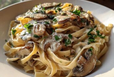 Close-up of rich Creamy Garlic Mushroom Pasta featuring fettuccine noodles, sliced mushrooms, and fresh parsley garnish.