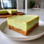 Close-up of a square slice of Creamy Key Lime Pie Bars showing the thick graham cracker crust and bright green filling.