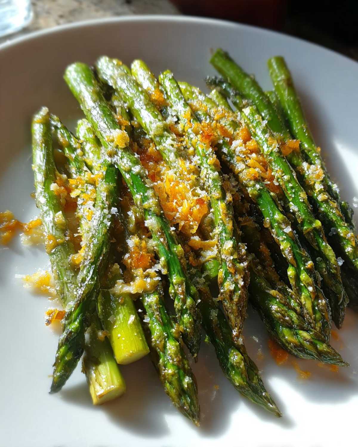 Close-up of bright green Crispy Roasted Asparagus A Side Dish for Christmas, topped with orange zest and coarse salt.
