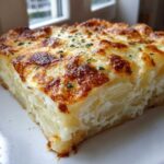 Close-up of a thick slice of creamy Easter Scalloped Potatoes with a golden, bubbly, cheesy crust.