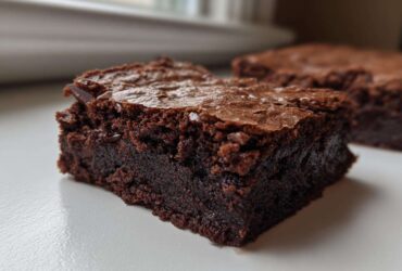 Close-up of a fudgy, dark chocolate slice of Brown Butter Brownies with a crackly top.