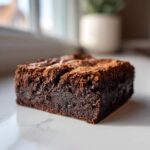 A close-up of a fudgy Brown Butter Brownies square showing a shiny, crackly top and dense interior.