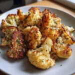Close-up of crispy oven-roasted Garlic Parmesan Roasted Cauliflower Crispy florets sprinkled with parsley.