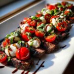Slices of Grilled Flank Steak Caprese topped with cherry tomatoes, mozzarella balls, basil, and balsamic glaze.