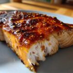 Close-up of a flaky Grilled Honey Mustard Salmon fillet with a shiny, caramelized glaze and visible mustard seeds.