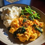 Plate featuring scrambled eggs with spinach, cottage cheese, and green vegetables, part of a What I Eat Daily for High Protein Fat Loss meal.