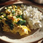 A plate featuring scrambled eggs with spinach and a serving of cottage cheese, part of a What I Eat Daily for High Protein Fat Loss meal.