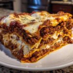 A thick, multi-layered slice of Homemade Classic Beef Lasagna showing rich meat sauce and melted cheese.