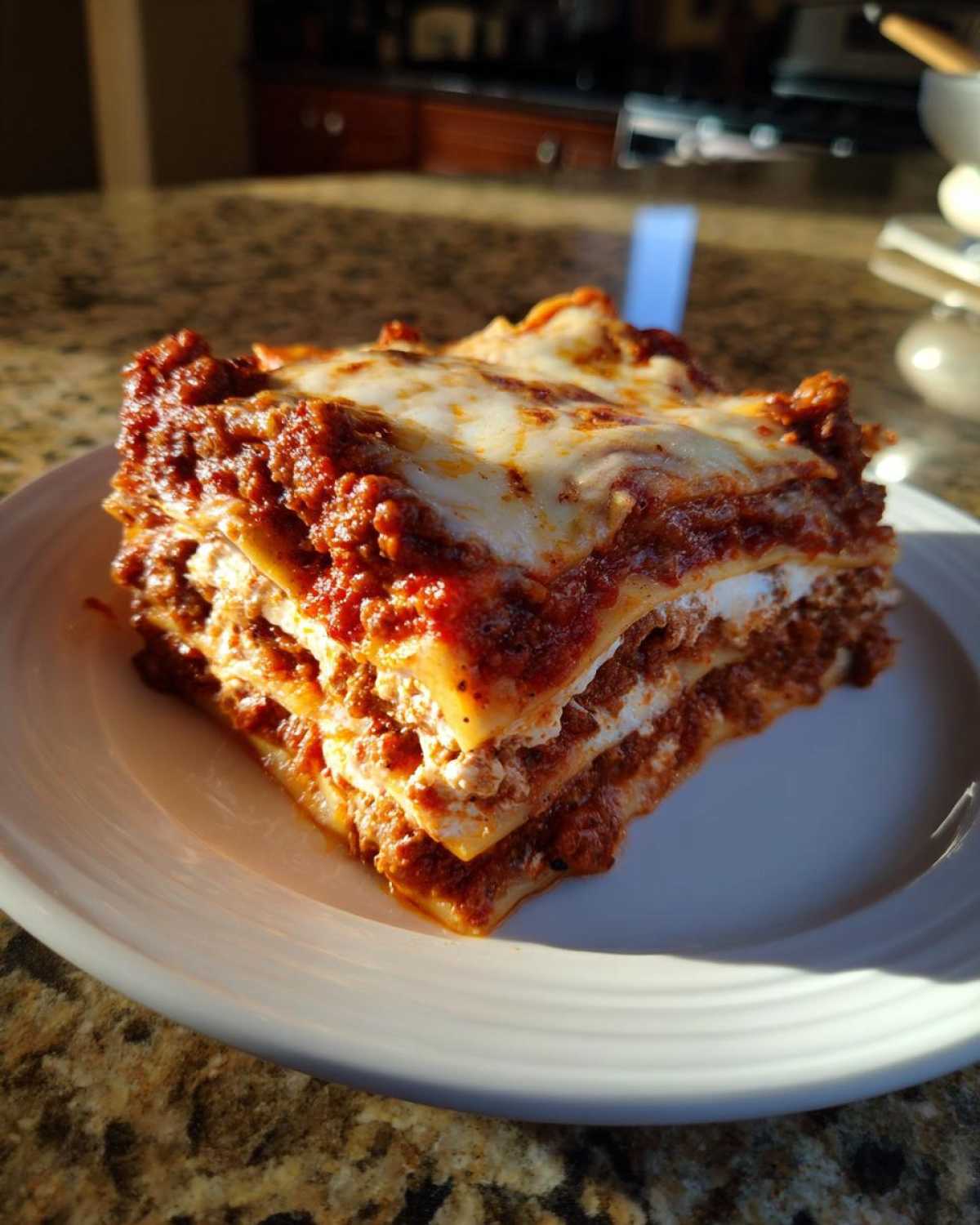A thick, layered slice of Homemade Classic Beef Lasagna with rich meat sauce and melted cheese.