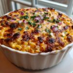Close-up of a baked Mexican Street Corn Dip Creamy, Cheesy & Irresistible topped with red onion and cilantro.