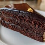 Close-up of a rich, dark slice of Moist & Unique Chocolate Cake Design with glossy ganache topping.