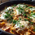 Close-up of delicious one-pot Lasagna Soup featuring bowtie pasta, rich tomato sauce, dollops of ricotta cheese, and fresh parsley.
