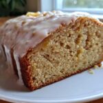 Close-up of a slice of moist Peach Pound Cake Almond Glaze showing the dense crumb and thick white icing.