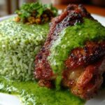 Close-up of crispy Peruvian Chicken and Rice with Green Sauce, featuring a piece of chicken topped with bright green sauce.