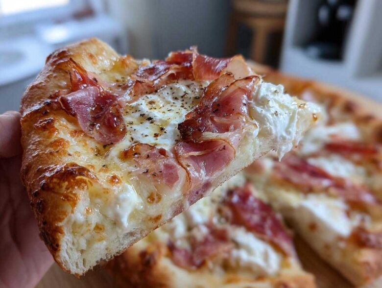 A close-up shot of a slice of Prosciutto Honey Burrata Pizza, showing melted cheese, ribbons of prosciutto, and dollops of creamy burrata.