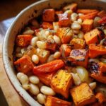 Close-up of a Rustic Roasted Vegetable Bake with Cannellini Beans featuring caramelized sweet potatoes and onions.