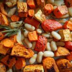 Close-up of roasted sweet potatoes, cannellini beans, onions, and rosemary for the Rustic Roasted Vegetable Bake.